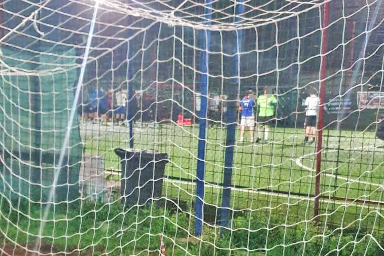 Una immagine scattata a bordo campo: sullo sfondo i soccorritori e i compagni del ragazzo svenuto