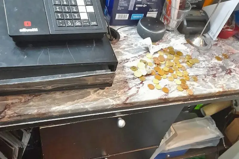 Gli spiccioli lasciati dai ladri accanto alla cassa del bar